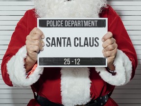 In this stock photo, Santa Claus poses for a police mugshot.