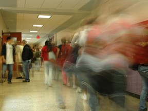 In this stock photo, high school students walk down a hallway.