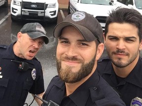 Michael Hamill (centre), gained attention after posing with two other officers in this selfie in September. (Facebook)