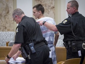 Justin Rey is escorted from the courtroom after an outburst and rant Thursday, Nov, 2, 2017, in Johnson County District Court in Olathe, Kan. Rey is charged with two counts of aggravated child endangerment and two counts of contributing to a child's misconduct. Lenexa police found Rey and two children sleeping inside a storage unit in the 9200 block of Marshall Drive. Police found the remains of Rey's wife Jessica Monteiro Rey, in coolers in the storage unit. Rey, who is being held on a $1 million bond, appeared without legal counsel.  (Tammy Ljungblad/The Kansas City Star via AP, Pool)