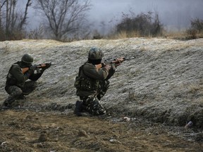 Indian paramilitary force soldiers take position at the site where suspected rebels stormed a paramilitary camp at southern Lethpora village in Indian controlled Kashmir, Sunday, Dec. 31, 2017.