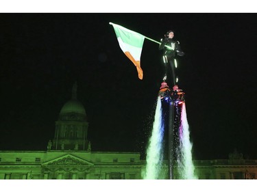 Members of Flyboard Ireland take part in the Liffey Lights Moment - Matinee in Dublin's city centre as part of the city's New Year's eve celebrations, Sunday Dec. 31, 2017. (Brian Lawless/PA via AP)
