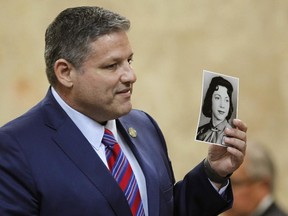 Hidalgo County Assistant District Attorney Michael Garza hold a photograph of Irene Garza as he presents his closing argument in John Feit's murder trial, Thursday, Dec. 7, 2017, at the Hidalgo County Courthouse in Edinburg, Texas. (Nathan Lambrecht/The Monitor via AP)