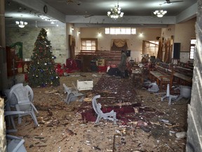 A Pakistani walks in the main hall of a church following a suicide attack in Quetta, Pakistan, Sunday, Dec. 17, 2017.  (AP Photo/Arshad Butt)