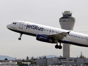 In this April 23, 2013, file photo, a JetBlue plane takes off in view of the air traffic control tower at Seattle-Tacoma International Airport, in Seattle.
