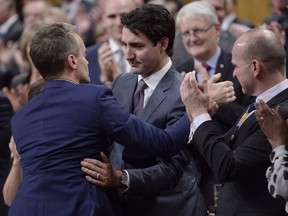 Prime Minister Justin Trudeau hugs Veterans Affairs Minister Seamus O'Regan after making a formal apology to individuals harmed by federal legislation, policies, and practices that led to the oppression of and discrimination against LGBTQ2 people in Canada, in the House of Commons in Ottawa, Tuesday, Nov.28, 2017.