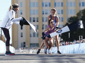 In this Sunday, Dec. 10, 2017, photo, Ariana Luterman, 17, back, helps Chandler Self cross the finish line during the BMW Dallas Marathon, as Shalane Flanagan, four-time Olympian, left, watches.