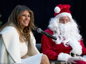 First lady Melania Trump, accompanied by Santa Claus, smiles as she takes questions from children before reading The Polar Express to children at Children's National Medical Center, Thursday, Dec. 7, 2017, in Washington.