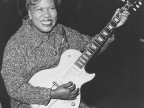 FILE- In this Nov. 21, 1957, file photo, Sister Rosetta Tharpe, guitar-playing American gospel singer, gives an inpromptu performance in a lounge at London Airport, following her arrival from New York. Tharpe, who died in 1973, will be inducted with the "Award for Early Influence" to the Rock and Roll Hall of Fame on April 14, 2018 in Cleveland, Ohio. (AP Photo, File)