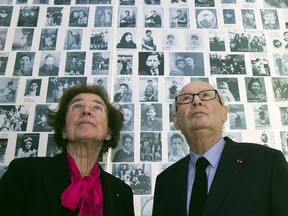 In this Tuesday, Dec. 5, 2017 photo, French Nazi hunters Beate Klarsfeld and her husband Serge Klarsfeld look at at photos of young Jews deported from France at the Shoah Memorial in Paris, France.