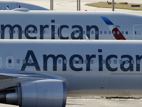 In this Monday, Nov. 6, 2017, file photo, a pair of American Airlines jets are parked on the airport apron at Miami International Airport in Miami.