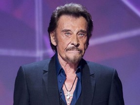 In this Friday, Feb. 12, 2016 file picture, French singer Johnny Hallyday gestures as he receives the best chanson album award during the 31st Victoires de la Musique, French music awards annual ceremony, in Paris, France. The French president's office says Hallyday, who packed sports stadiums for decades, has died at age 74.