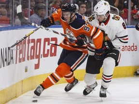 Chicago Blackhawks' Nick Schmaltz (8) and Edmonton Oilers' Connor McDavid (97) battle for the puck during second period NHL action in Edmonton on Friday December 29, 2017.