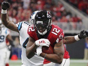 Atlanta Falcons wide receiver Mohamed Sanu (12) runs as Carolina Panthers defensive back Captain Munnerlyn (41) defends during the first half of an NFL football game, Sunday, Dec. 31, 2017, in Atlanta.