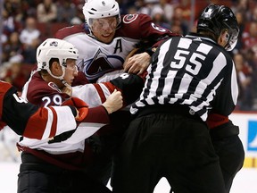 Arizona Coyotes' Zac Rinaldo, back right, is attacked by Colorado Avalanche centre Nathan MacKinnon and defenceman Erik Johnson on Dec. 23, 2017