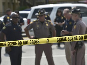 Police stand behind a crime scene tape near the mass shooting at the Pulse nightclub on in Orlando, Florida on June 12, 2016.