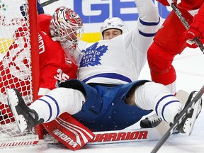 Toronto Maple Leafs left winger Matt Martin lands on Detroit Red Wings goalie Jimmy Howard on Dec. 15, 2017