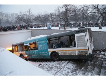 Pedestrians stand around the scene of a bus crash in Moscow, Russia, Monday, Dec. 25, 2017. (AP Photo/Ivan Sekretarev)