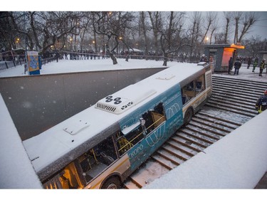 Pedestrians stand around the scene of a bus crash in Moscow, Russia, Monday, Dec. 25, 2017. (AP Photo/Ivan Sekretarev)