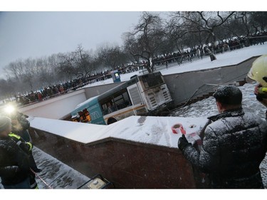 Pedestrians stand around the scene of a bus crash in Moscow, Russia, Monday, Dec. 25, 2017. (AP Photo/Ivan Sekretarev)