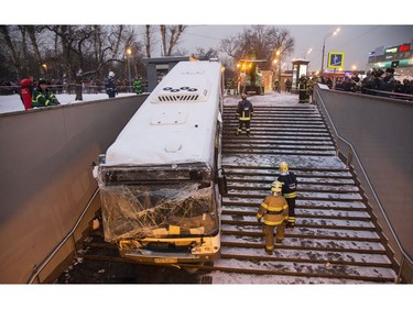 Emergency personnel work to pull a bus that crashed out from a subway in Moscow, Russia, Monday, Dec. 25, 2017. (AP Photo/Ivan Sekretarev)