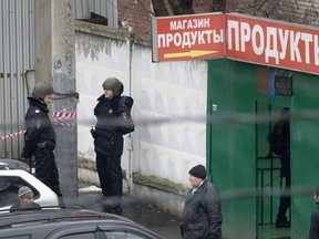Police officers stand guard, outside a candy factory after an incident, in Moscow, Russia, Wednesday, Dec. 27, 2017. The former owner of a candy factory in Moscow has killed a security guard and injured three people, Russian investigators said Wednesday. The Investigative Committee said the man argued with the factory's new owner and then opened fire with a shotgun.