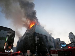 Smoke rises as firefighters try to extinguish a fire at an eight-floor building in Jecheon, South Korea, Thursday, Dec. 21, 2017.