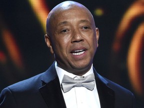 FILE - In this Feb. 6, 2015, file photo, hip-hop mogul Russell Simmons presents the Vanguard Award on stage at the 46th NAACP Image Awards in Pasadena, Calif. Simmons announced on Nov. 30, 2017, he would be stepping down from companies he founded following a new allegation of sexual misconduct.