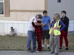 Ron Lawrence, left, comforts his daughter Kallie Lawrence, 11, who knew the  boy that was killed in the shootout between Bexar County Deputies and a wanted woman in Pecan Grove Trailer Park in Schertz, Texas, on Thursday, Dec. 21, 2017.