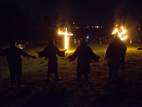 In this Saturday, April 23, 2016 photo, members of the Ku Klux Klan participate in cross and swastika burnings after a "white pride" rally in rural Paulding County near Cedar Town, Ga.