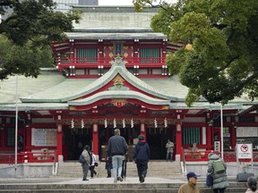 People visit Tomioka Hachimangu shrine in Tokyo on Friday, Dec. 8, 2017. Police say three people have died in a stabbing attack on Thursday night at the prominent shrine, including the head priest and the attacker, who apparently took his own life. (AP Photo/Eugene Hoshiko)