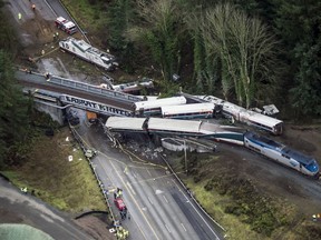 In this Dec. 18, 2017, file photo, cars from an Amtrak train that derailed lie spilled onto Interstate 5 in DuPont, Wash. (AP Photo/Bettina Hansen)