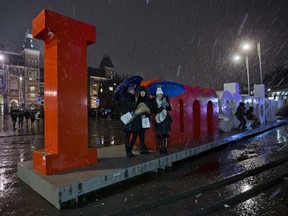 Tourists pose for pictures with the "I Amsterdam" sign outside the Rijksmuseum, rear left, in Amsterdam, Netherlands, Friday, Dec. 8, 2017.