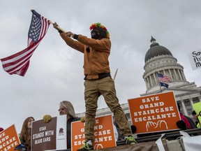 Protesters gather outside of the Utah State Capitol where President Donald Trump spoke to local representatives on Monday, Dec. 4, 2017, in Salt Lake City. Roughly 3,000 demonstrators lined up near the State Capitol to protest Trump's announcement of scaling back two sprawling national monuments, and his declaring that "public lands will once again be for public use." (Benjamin Zack/Standard-Examiner via AP)