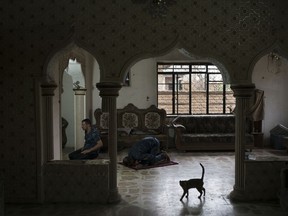 In this Nov. 9, 2017, photo, Federal policemen pray inside an abandoned house used as a temporary base in the hospital complex where the morgue was located in Mosul, Iraq. Much of the complex was destroyed in fighting to wrest the city from Islamic State group militants earlier this year.