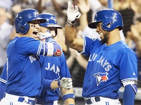 Toronto Blue Jays' Ryan Goins, left, celebrates his grand-slam against the New York Yankees with Kevin Pillar, back, and Teoscar Hernandez, right, in the sixth inning in their American League MLB baseball game in Toronto on Friday, September 22, 2017. THE CANADIAN PRESS/Fred Thornhill