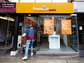 A man enters the store at the new rebranding sign of Freedom Mobile in Toronto on Thursday, November 24, 2016.