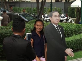 A member of the public takes their picture with a life-sized cardboard cutout of Thai Prime Minister Prayuth Chan-ocha on Jan. 8, 2017 in Bangkok, Thailand.