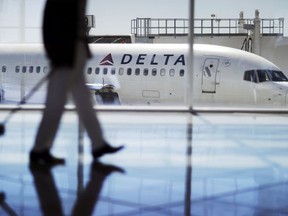 In this Thursday, Oct. 13, 2016, photo, a Delta Air Lines jet sits at a gate at Hartsfield-Jackson Atlanta International Airport in Atlanta.
