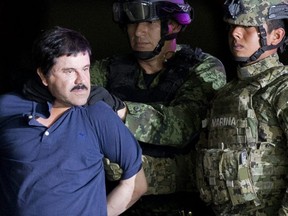 In this Jan. 8, 2016 file photo, a handcuffed Joaquin "El Chapo" Guzman is made to face the press as he is escorted to a helicopter by Mexican soldiers and marines at a federal hangar in Mexico City. (AP Photo/Eduardo Verdugo)