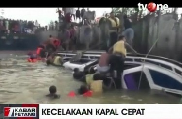 In this image taken from video released by TV One, passengers are helped from a boat that capsized off Indonesia's part of Borneo island on Monday Jan. 1, 2018. (TV One via AP)