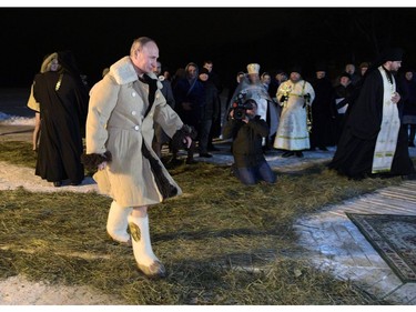 Russian President Vladimir Putin walks to plunge into the icy waters of lake Seliger during the celebration of the Epiphany holiday in Russia's Tver region early on January 19, 2018.