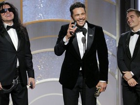 This image released by NBC shows James Franco, center, accepting the award for best actor in a motion picture comedy or musical for his role in "The Disaster Artist," as Tommy Wiseau, left, and brother Dave Franco look on at the 75th Annual Golden Globe Awards in Beverly Hills, Calif., on Sunday, Jan. 7, 2018. (Paul Drinkwater/NBC via AP)