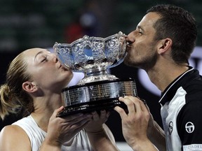 Canada's Gabriela Dabrowski, left, and Croatia's Mate Pavic kiss their trophy after defeating Hungary's Timea Babos and India's Rohan Bopanna in the mixed doubles final at the Australian Open tennis championships in Melbourne, Australia, Sunday, Jan. 28, 2018.