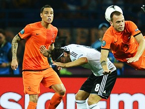 German midfielder Mesut Oezil (C) vies with Dutch defender John Heitinga (R) under the look of Dutch defender Gregory van der Wiel during the Euro 2012 championships football match the Netherlands vs Germany on June 12, 2012 at the Metalist Stadium in Kharkiv. AFP PHOTO/ PATRIK STOLLARZPATRIK STOLLARZ/AFP/GettyImages