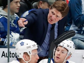 Toronto Maple Leafs coach Mike Babcock confers with players during the first period of an NHL game against the Colorado Avalanche on Dec. 27, 2017