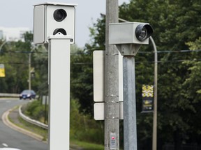 Red light cameras are seen at an intersection in downtown Toronto on Aug. 11, 2017. Police in Rhode Island say two people unbolted and stole an $80,000 camera used to catch speeding drivers.