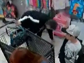 In this screenshot, a woman picks up a $100 bill that fell from a woman's hand in a Burlington Coat Factory on Nov. 4, 2017 in Warwick, R.I.