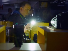 An attendee uses a flashlight on his smartphone to view a display at the Nikon booth after power was lost inside the central hall during CES 2018 at the Las Vegas Convention Center on Jan. 10, 2018 in Las Vegas.  (David Becker/Getty Images)