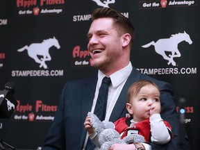 Calgary Stampeders linebacker Rob Cote holds his son Wynn as he announces his retirement at McMahon Stadium on Tuesday, Jan. 23, 2018.